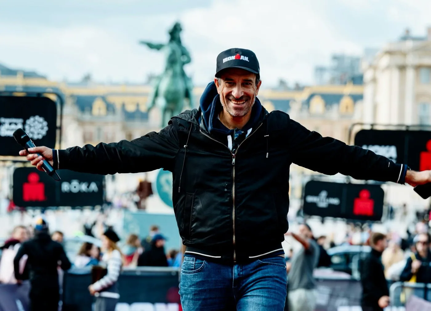 Julien Huët, speaker à l’IRONMAN 70.3 Versailles, micro en main devant le château